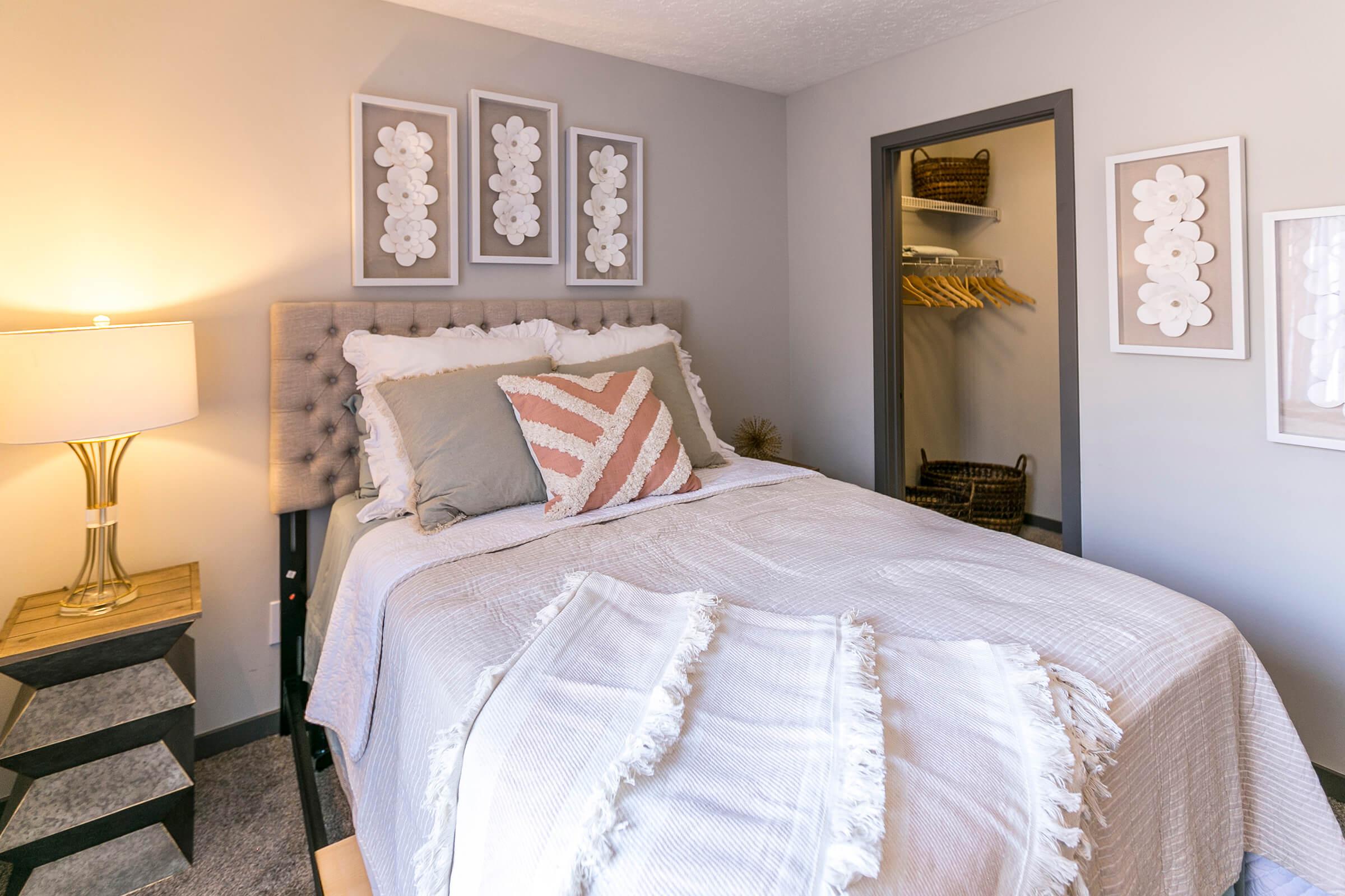 Cozy bedroom with white bedding and soft lighting.